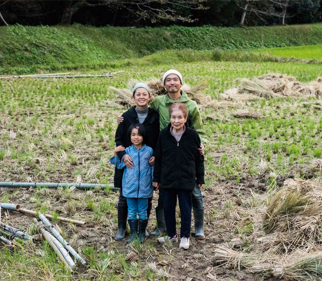 脱穀を終えた田んぼで家族４人で記念撮影