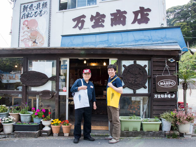 〈ひもの万宝〉の平井さん親子が干物トートバッグをもって一枚