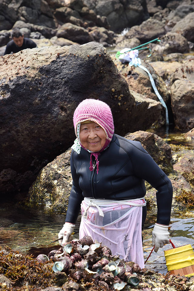 獲った貝類を岩場にあげる