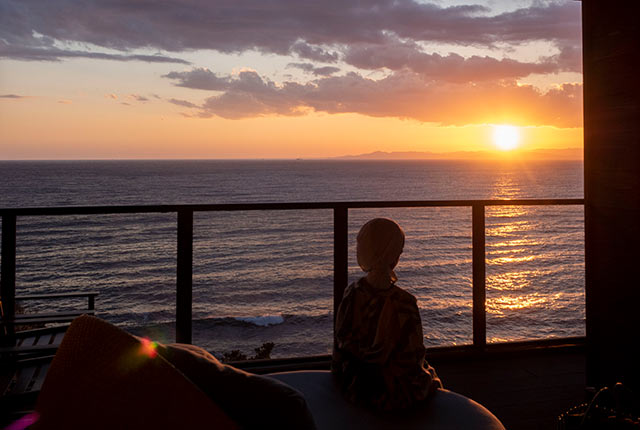 ホテルのベランダから夕日を眺める
