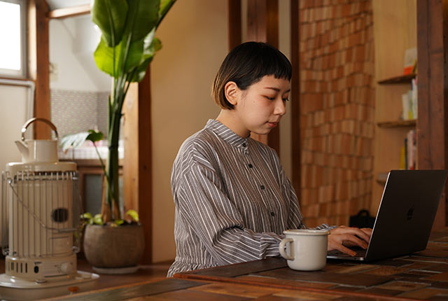 客室でノートパソコンを開き仕事中