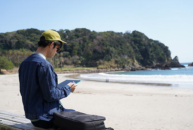 浜辺でタブレットを開く