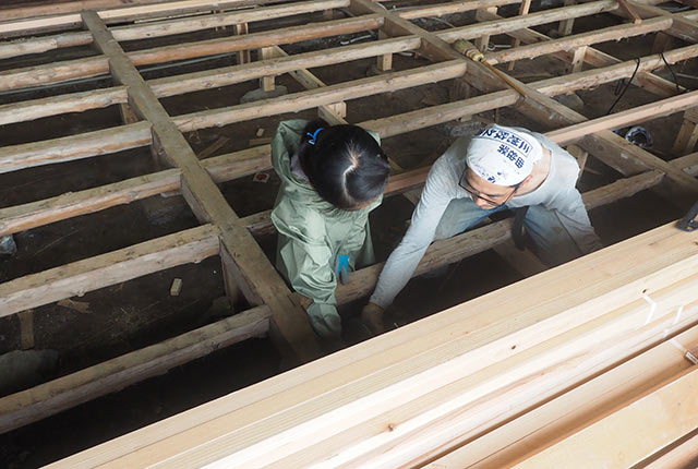 床下にしゃがんで作業中