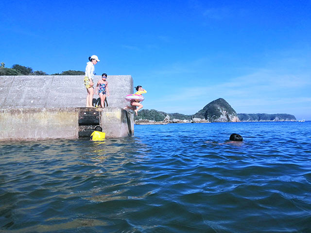 桟橋から海に飛び込む子供