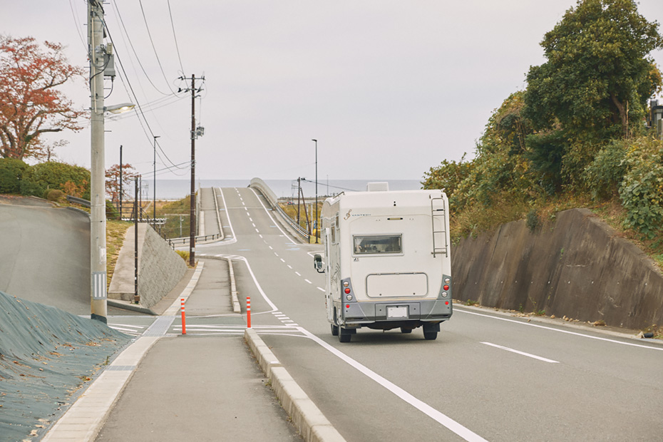 海へ向かってのびる汐橋を走るキャンピングカー