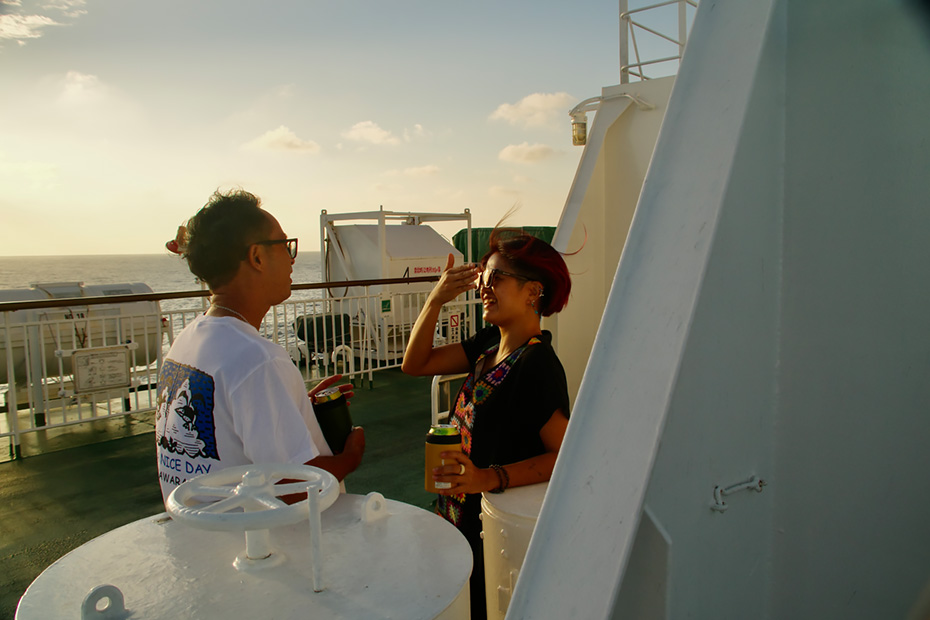 日が沈む中、船の甲板では各々が自由に過ごしていた