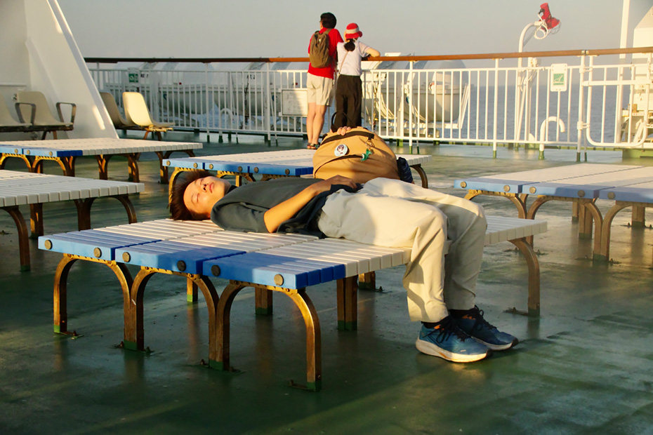 日が沈む中、船の甲板では各々が自由に過ごしていた