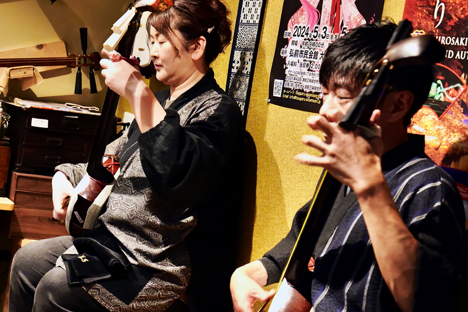 津軽三味線を演奏する女将の田辺美幸（東日流賀乃）さんと小山内薫さん。