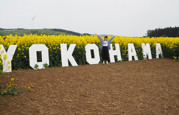 横浜町の菜の花畑をバックに。(写真提供:佐々木芽)
