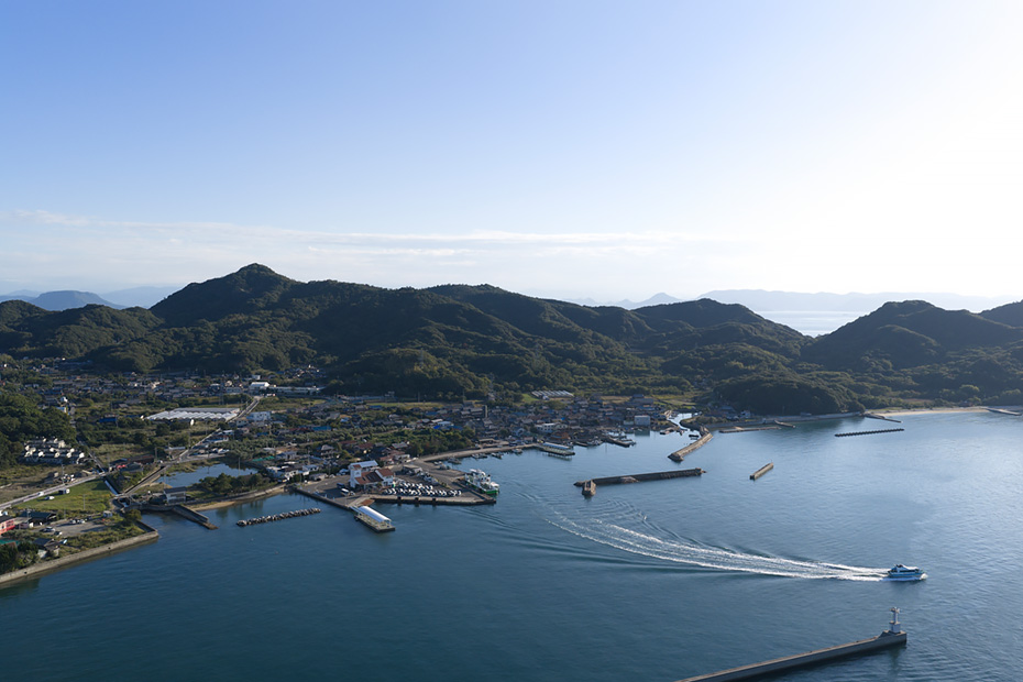 〈豊島〉の海の玄関口、岡山・香川方面や直島・犬島・小豆島とフェリーで結ぶ寄港地、家浦港。緑に覆われた山、そして白砂の海水浴場も見られる